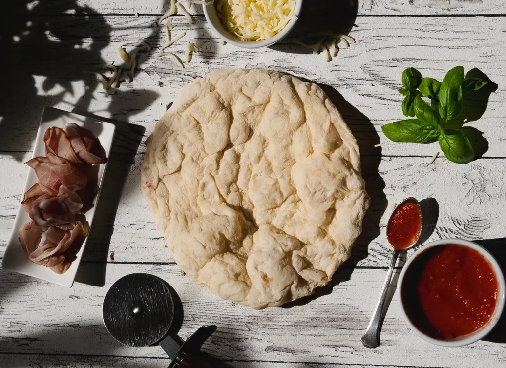 Auf Stein vorgebackener Pizzaboden mit frischen Zutaten